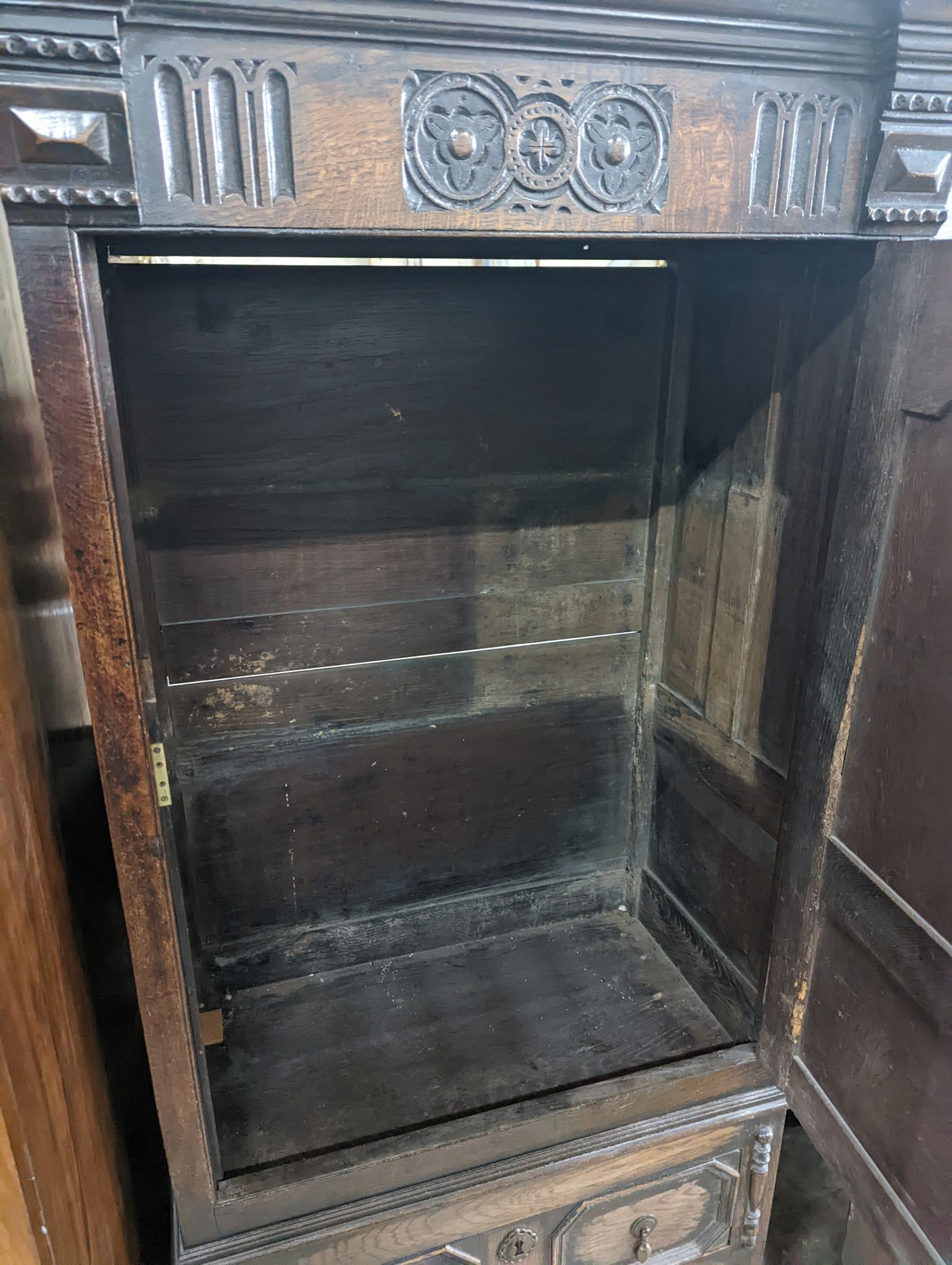 A 17th century style carved panelled oak side cabinet, width 76cm, depth 43cm, height 173cm